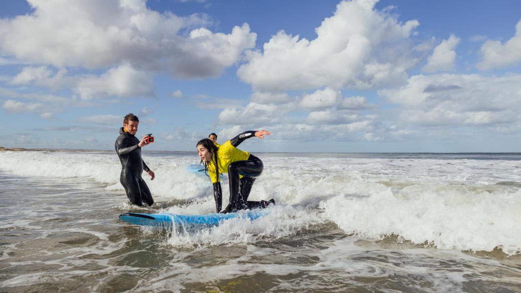 Woman riding a small wave during a surf lesson