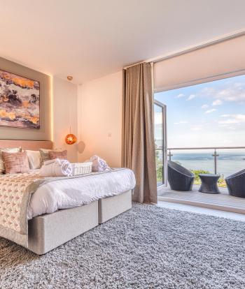Room 43 at Sandy Cove Hotel featuring modern decor and a balcony with a view over the sea