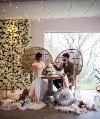 A newly-wed couple inside The Venue at Sandy Cove with decorations for their winter wedding