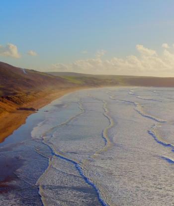 An aerial view over Woolacombe and Putsborough beaches in North Devon at sunset