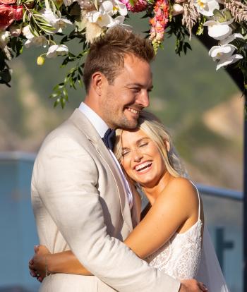 A bride and groom hugging on their wedding day at The Venue, Sandy Cove Hotel