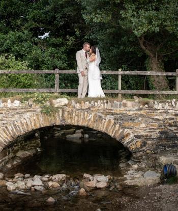 Bride and groom standing on a bridge