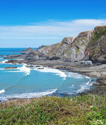 View of Hartland quay near the town of Bideford in North Devon, dark rock formations, blue sea, selective focus