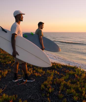 Two male surfers checking the waves from the shore