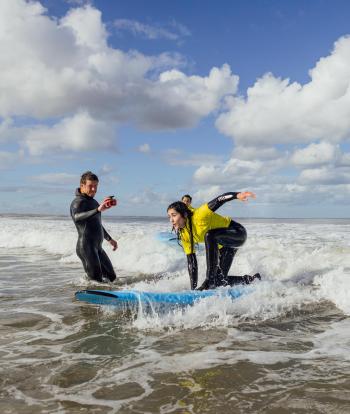 Woman riding a small wave during a surf lesson