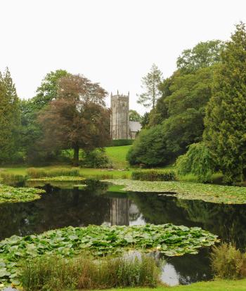 View of St James Church from across the Lake in the Grounds of Arlington Court, near Barnstaple, Devon, England, UK
