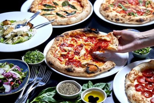 A selection of pizzas on a table in one of Sandy Cove Hotel's restuarants