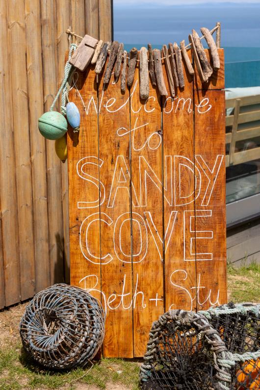 A wedding sign made of drift wood and lobster pots outside The Venue at Sandy Cove Hotel