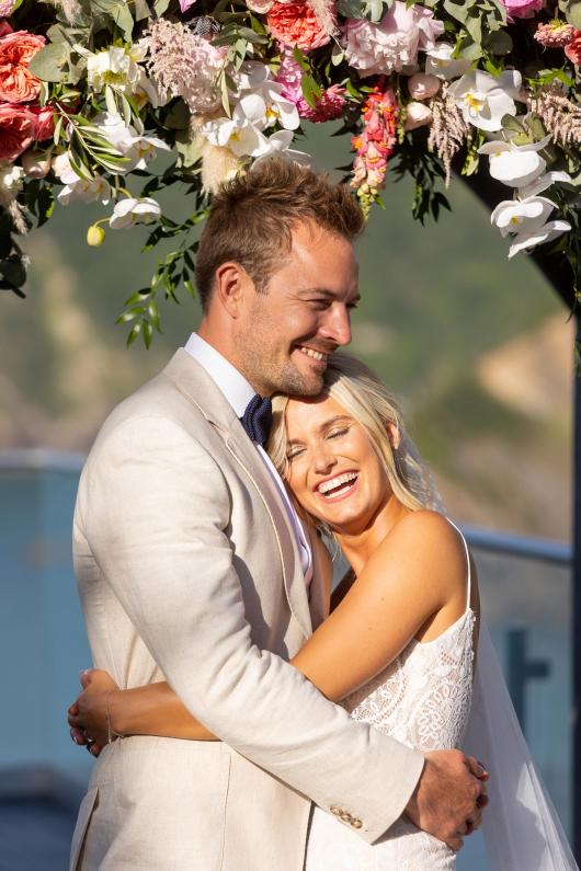 A bride and groom hugging on their wedding day at The Venue, Sandy Cove Hotel