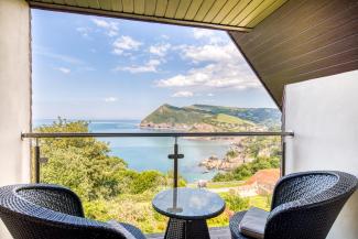 Nest Egg Chairs on the private covered balcony overlooking the bay in one of Sandy Cove Hotel's Deluxe Sea View with Balcony rooms